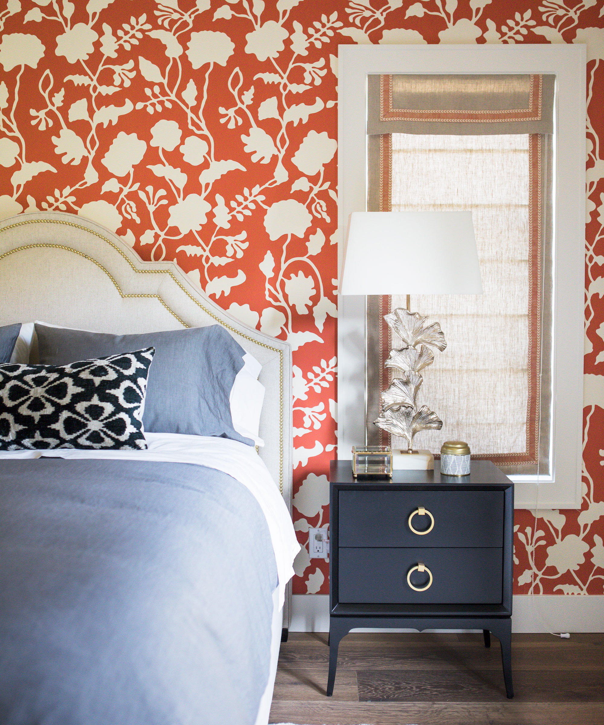 Dormitorio naranja con papel tapiz enrejado y ropa de cama azul