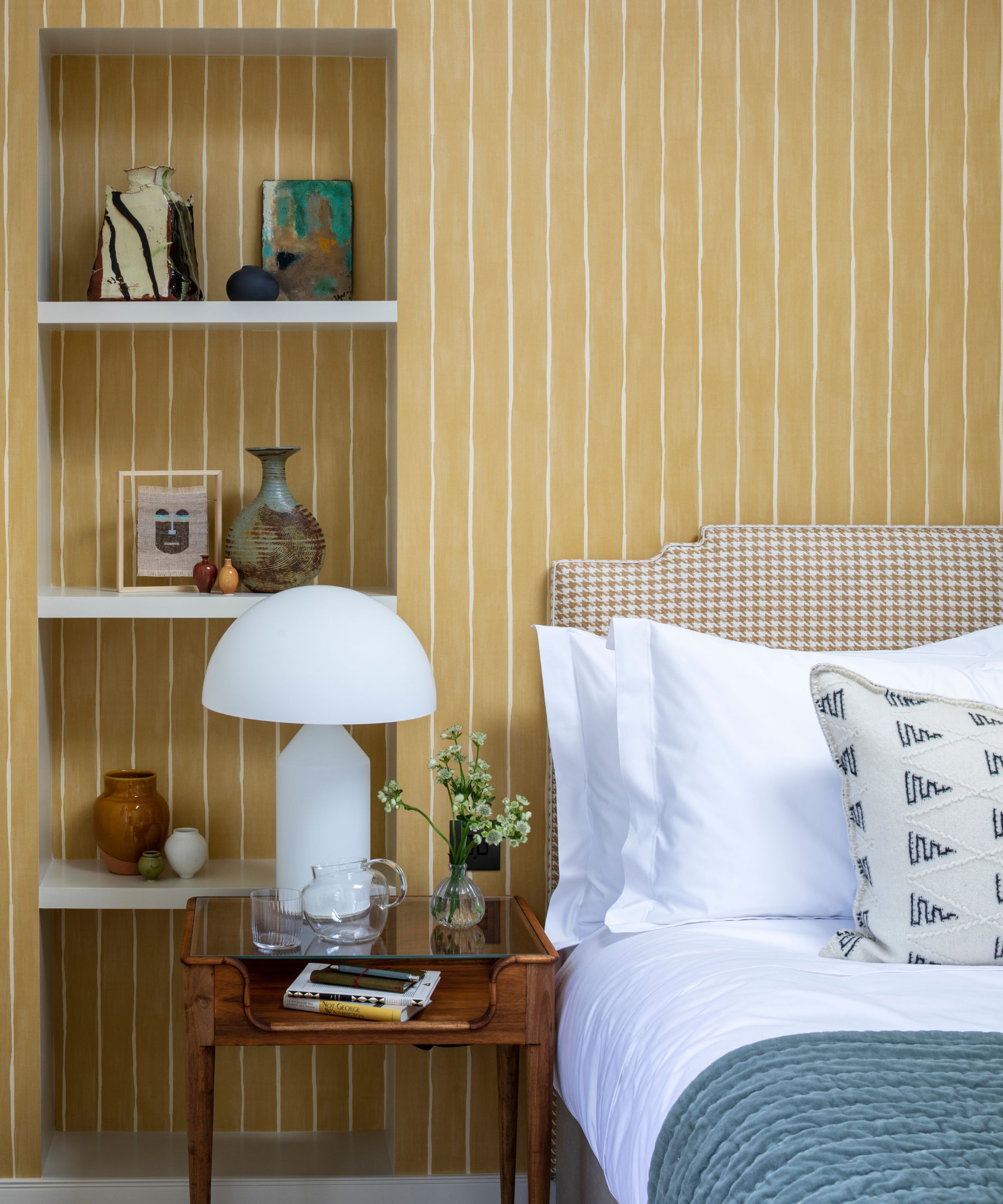 Dormitorio amarillo con estanterías alcoba al lado de la cama