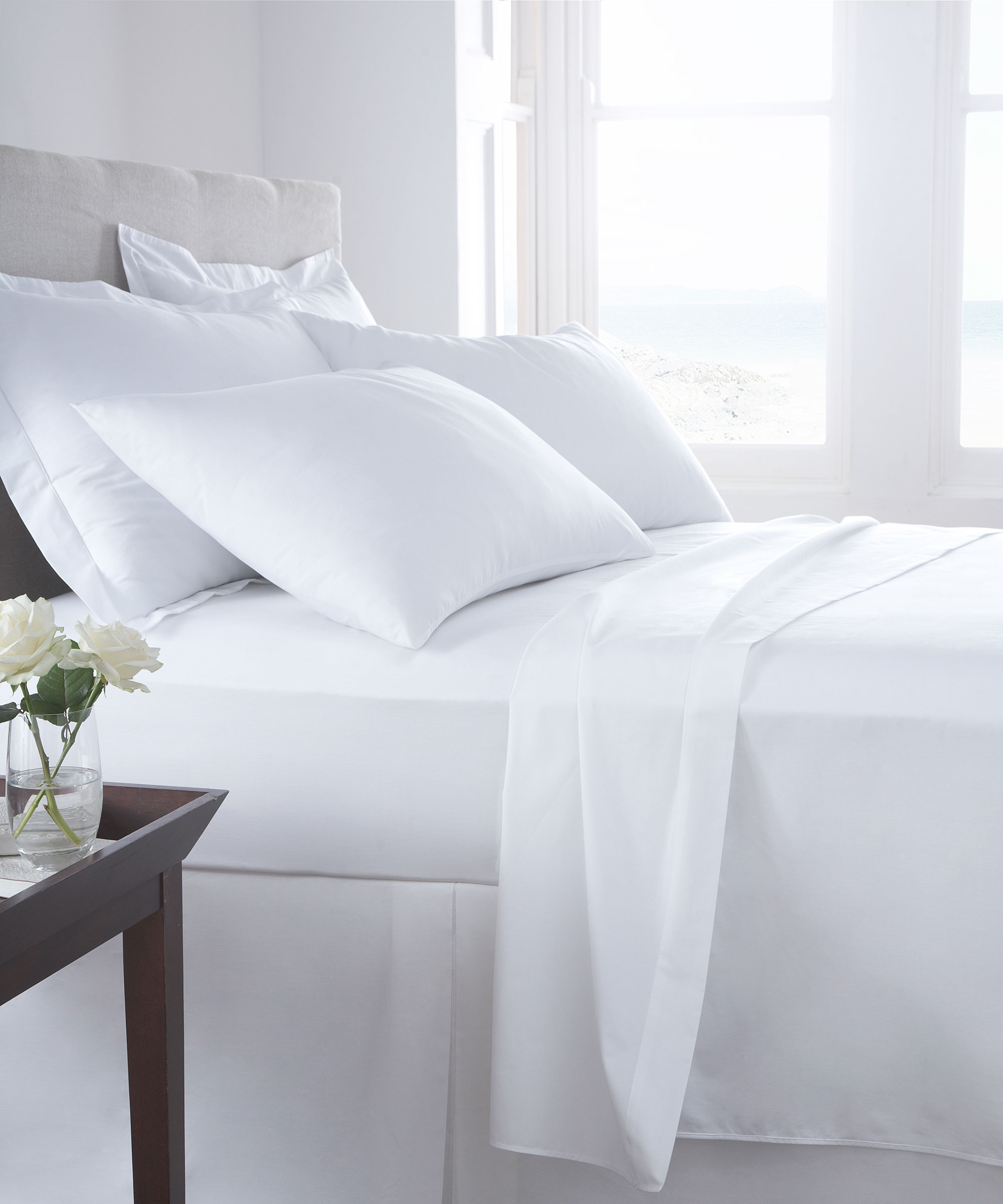 ropa de cama blanca y almohadas en el dormitorio